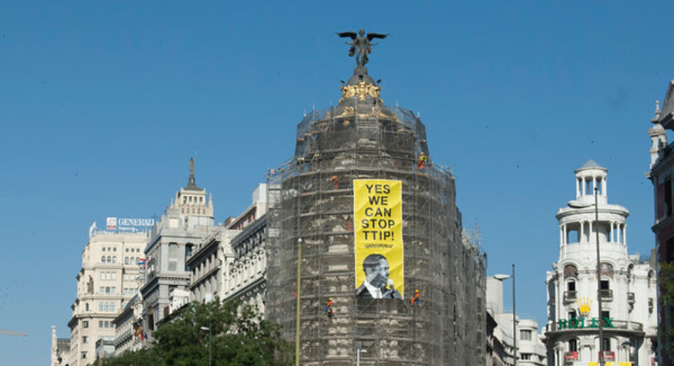 Activistas de Greenpeace cuelgan una pancarta en el edificio Metrópolis de Madrid para pedir a Obama que pare el TTIP
