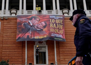 Greenpeace cuelga en la Gran Vía de Madrid un gran cartel de cine con Rajoy y el ministro Nadal de protagonistas para denunciar la política energética del Gobierno