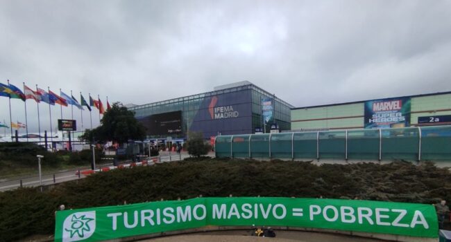 Ecologistas en Acción despliega una pancarta gigante en FITUR para denunciar los impactos de la masificación turística 